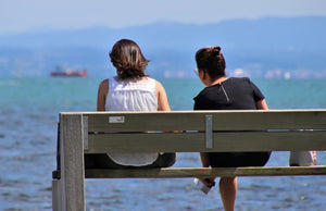Two women (one with hearing loss) talking at beach