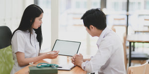 Woman showing a man an audiogram test on a tablet 