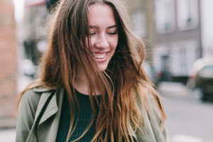 woman walking down street smiling 