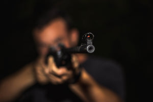 man wearing earplugs and shooting a gun 